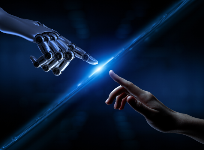 Human and Robot Hands with a screen in the middle indicating the cooperation between humans & AI 