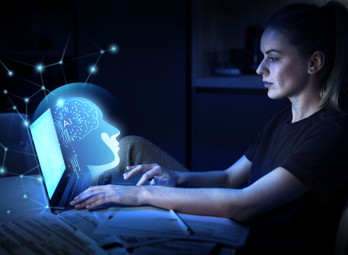 Woman using laptop with brain icon, symbolizing technology and intelligence.